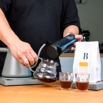  Man using the Delter Coffee Press outdoors, enjoying a freshly brewed cup 